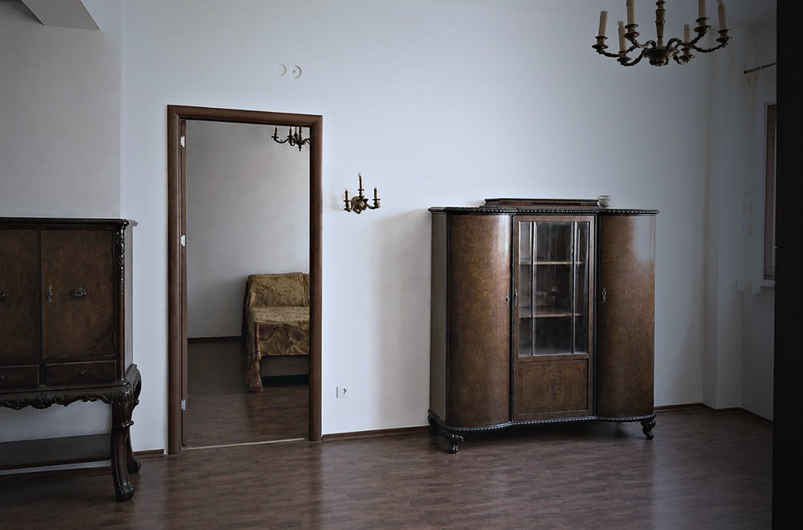 Livingul apartamentului înainte de renovare: mobilier vechi, parchet uzat, tavan cu candelabru.