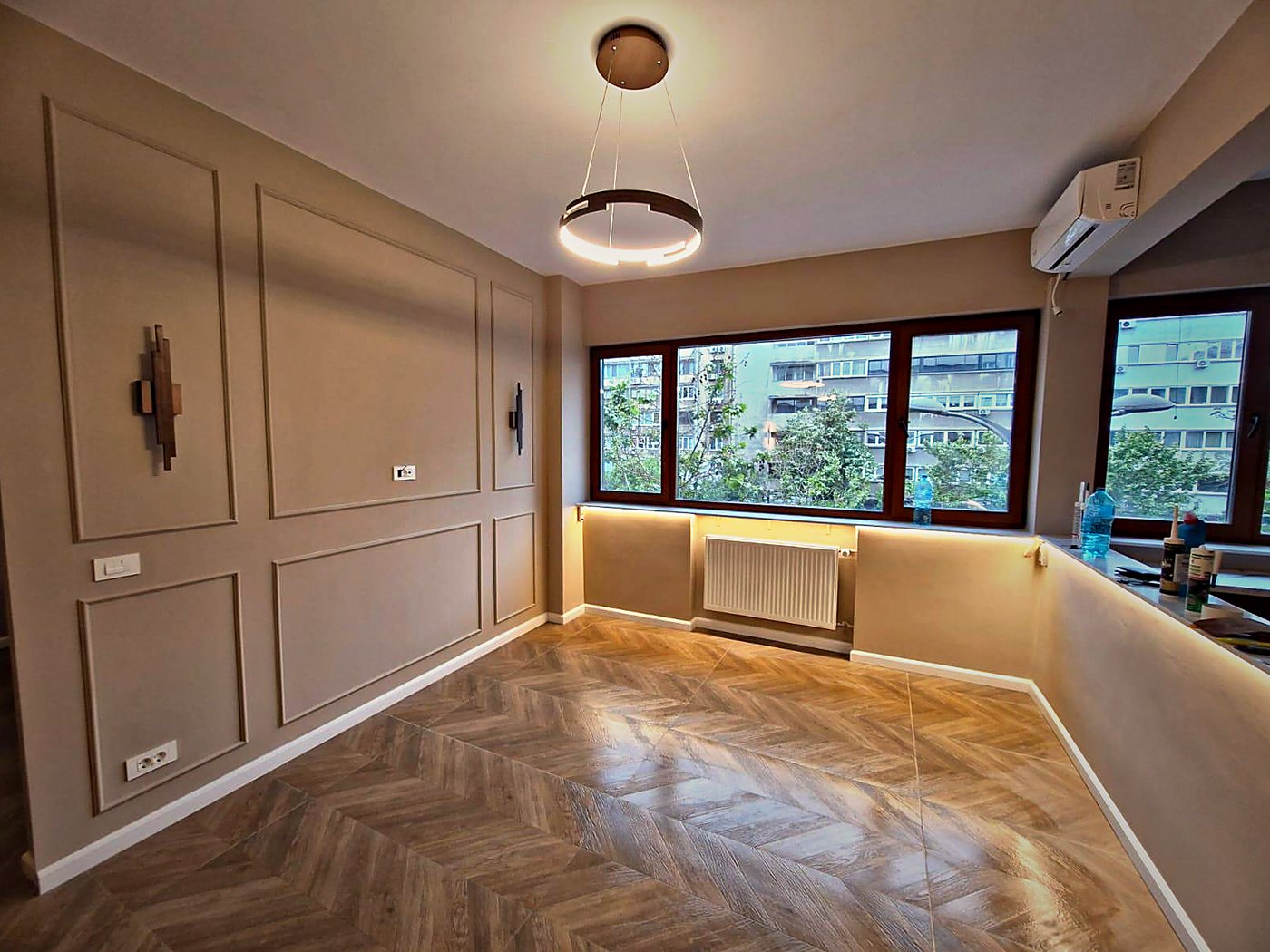 Livingul finisat, cu boiserie, parchet în spic și iluminat de nișă